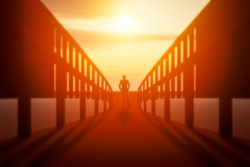 Foto op Canvas A man stands on the bridge and looks into the distance at the sunset. © sv_production