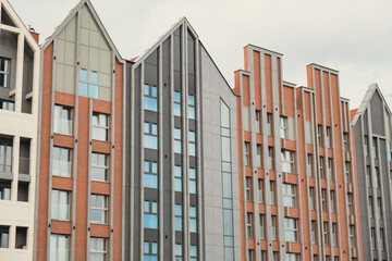 Modern office building exterior with glass facade on clear sky background. Transparent glass wall of office building with yellow decoration. Abstract Structure Element of facade of modern European