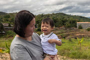 Portrait image happy mother with Happy 1-2 years old Asian Chinese child at nature fruit farm