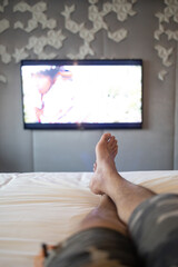 man leg relaxing on hotel bed