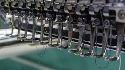 Extreme close-up of Embroidery machine needle in Textile Industry at Garment Manufacturers,...