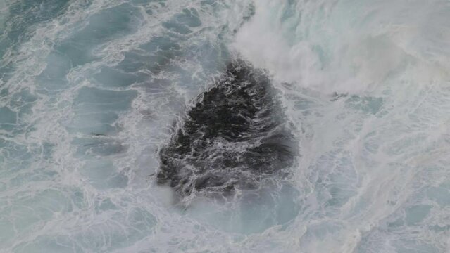 Waves crashing onto rocks in slow motion