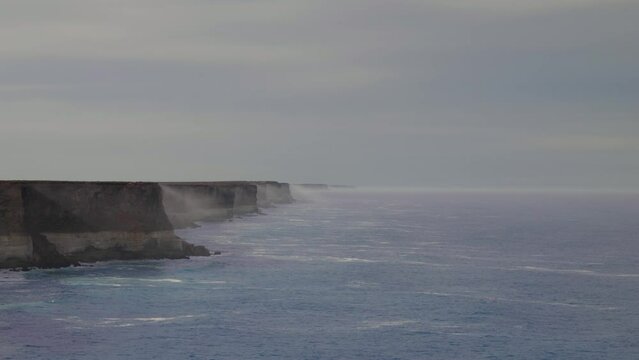 Sun rays in the mist at spectacular coast. Nullarbor Cliffs