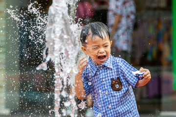 A carefree child reveling in the simple pleasures of summer, as they dance amidst the playful spray...