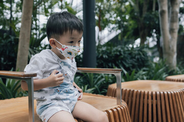 Portraiture image of A Happy Kid with medical face mask Flourishing in the Indoor Garden