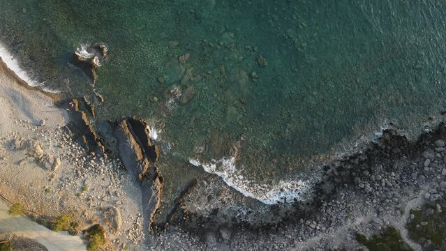 West Crete fly over though rocks and ocean during golden hour sunset phase