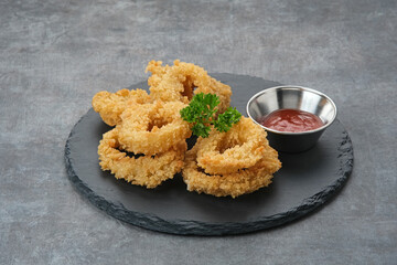 Crunchy fried onion rings with tomato sauce
