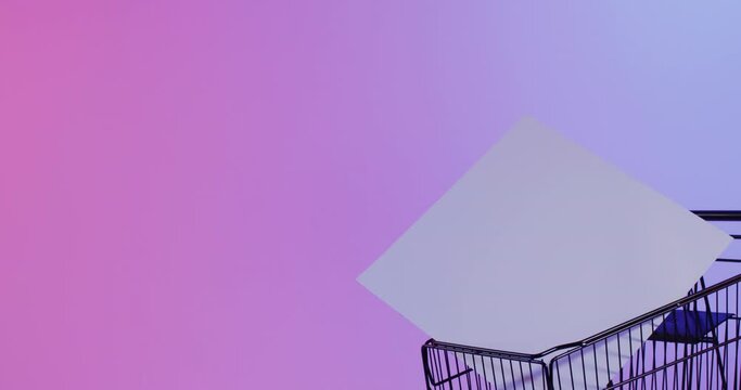 Video of shopping trolley and canvas with copy space over neon pink background