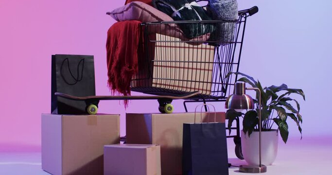 Video of shopping trolley and shopping with copy space over neon pink background