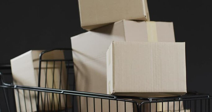 Video of shopping trolley and boxes with copy space over grey background