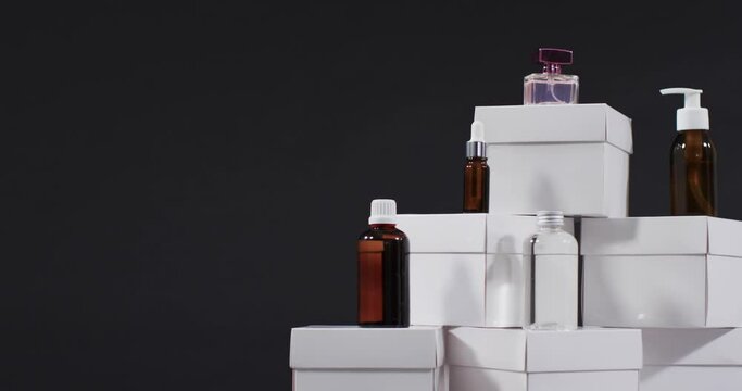 Video of beauty products with white cardboard boxes with copy space over black background