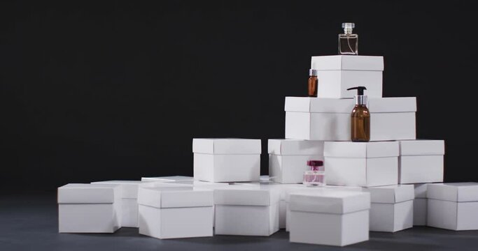 Video of beauty products with white cardboard boxes with copy space over black background