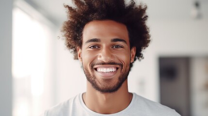 Young black man with afro hair smiling with perfect smile and white teeth.