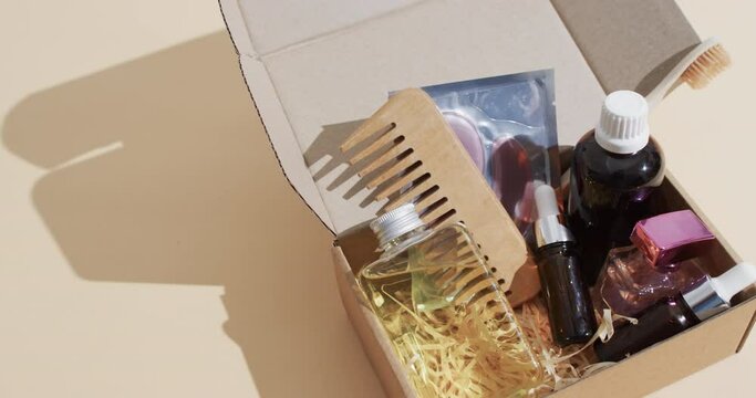 Video of beauty products in cardboard box with copy space over brown background