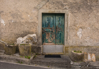 Fototapeta na wymiar A door in an historic stone house in the mountain village of Mieli near Comeglians in Carnia, Friuli-Venezia Giulia, north east Italy