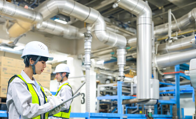 工場の配管を点検するエンジニア