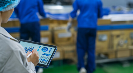 Workers using tablets at a distribution center.