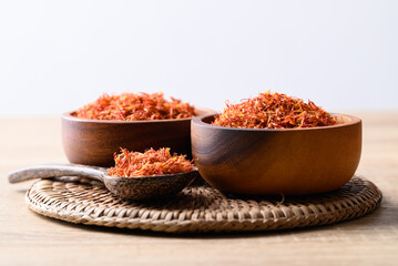 Fototapeta na wymiar Dried safflower in wooden bowl and spoon, Herbal tea