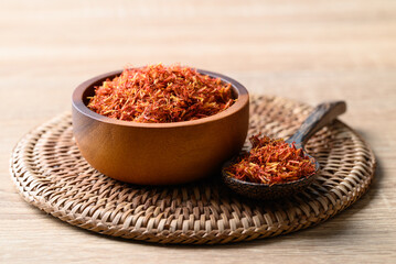 Dried safflower in wooden bowl and spoon, Herbal tea