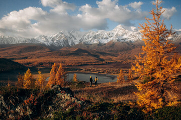 
couple in love on a lake in which mountains are reflecte