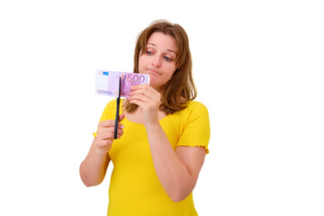 A woman cuts a bill of 500 euros with scissors, isolated on a white background. Wasted money spent on apartment renovation