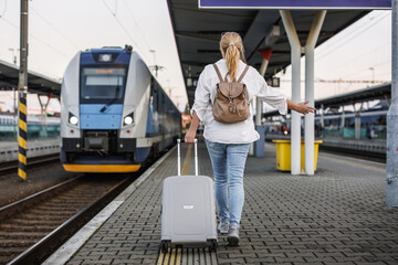 Woman traveling by train. Tourist with suitcase in hurry at railroad station platform. Travel lifestyle © encierro
