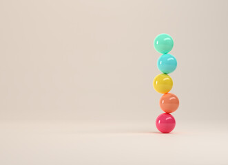 Colorful spheres balancing on top of each other on white background.