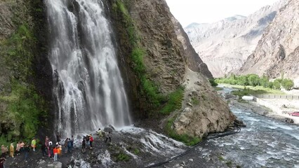 Happy tourists enjoy at a Waterfall. Tourist visits the waterfall in the mountains. Travel, Active lifestyle travel people standing in the background beautiful waterfall, standing near the waterfalls.