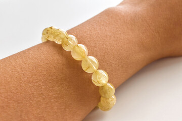 Golden rutilated quartz bracelet on the wrist. Spiritual, wealth, prosperity and healing crystal gemstone. 