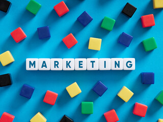 Fototapeta na wymiar Business marketing concept. Colorful cubes on blue background with the word marketing.