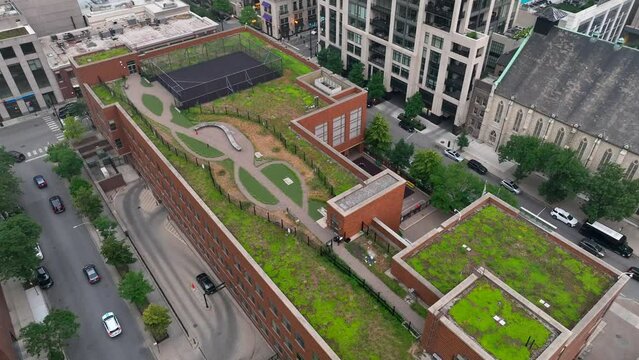 Green roof on apartment building in downtown city in USA. Aerial establishing shot of livable green space fighting climate change.