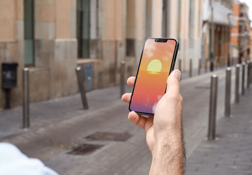 Mockup of person holding mobile phone with customizable screen in urban setting