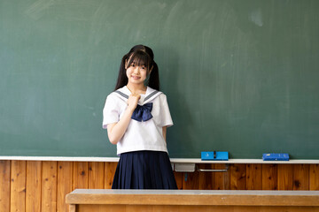 学校の教室の黒板と中学生の女の子