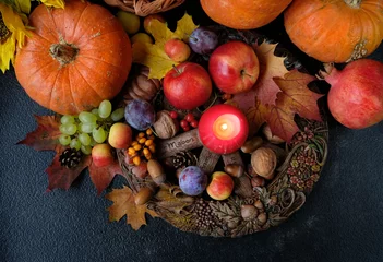 Zelfklevend Fotobehang Wiccan altar for Mabon sabbat. fruits, pumpkins, candle, nuts and wheel of the year on abstract dark background. Witchcraft, esoteric spiritual ritual for fall season. symbol of Harvest. top view © Ju_see