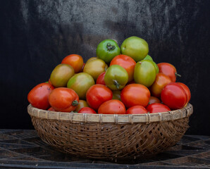 Green and ripe tomatoes give their name to a bamboo basket