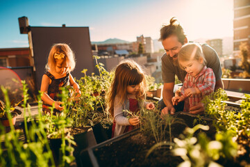 Young family, one parent and three children, gardening on their rooftop