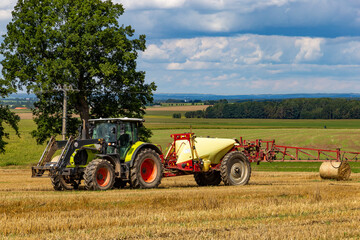 Fototapeta premium Agricultural machinery in summerfield. Rural landscape.
