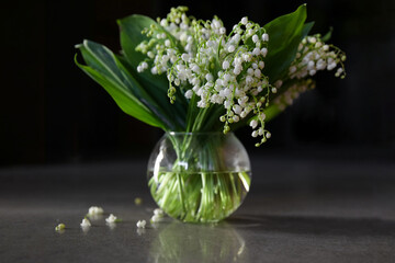 Still life a bouquet of white lilies of the valley in a glass vase