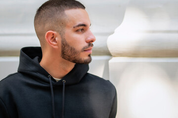 Portrait of a stylish young man standing in a city street and smiling