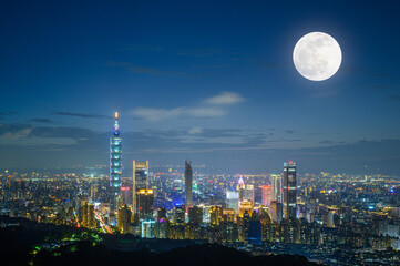 Fototapeta premium Urban Splendor at Night: Watching Dynamic Clouds Above a Dazzling Cityscape. View of Taipei city from the Four Beasts Mountain Trail, Taiwan