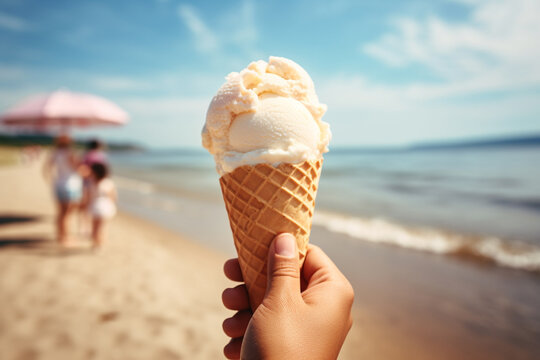 A person hand holding a gelato ice cream cone in his hand on the beach