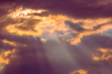 Obraz premium A mystical atmosphere is created by the weather, which showcases a dramatic sky with sunlight breaking through holes in dark clouds