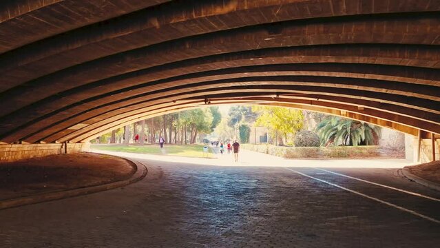 A walk through Turia Park in Valencia. A popular place for city residents and tourists for active recreation. Jogging and cycling paths under the bridge arch.