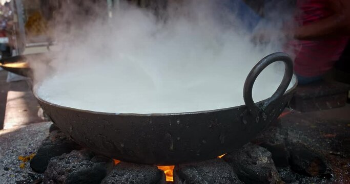 Indian street food: cooking boiled sweet milk cake on market in Pushkar, India. Indian sweets food mawa. The cheese obtained by reducing milk is known as Mawa. Rajasthan, Western India