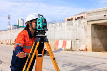 engineer use theodolite equipment  for route surveying to build a bridge across the intersection to reduce traffic congestion during rush hours