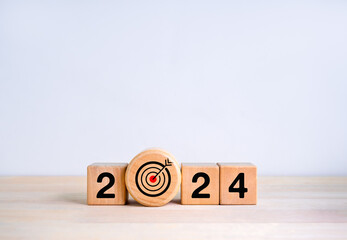 Happy 2024 calendar year with goal and success concepts. Big wood target dart icon and 2024 year number on wooden cube block isolated on white background. Happy new year, big business goals banner.