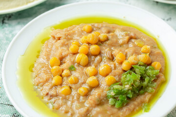 close up view of Arab middle eastern traditional breakfast dish of mashed beans with olive oil and ground green pepper 