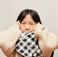 暖かいセーターとマフラーを着ている子供の様子