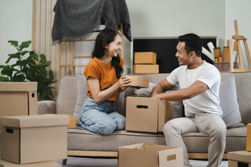 young couple helps put things in boxes and prepares, smiling happy moving to a new house.