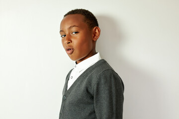 Elegant schoolboy looking at camera with confident facial expression showing off in front of camera...
